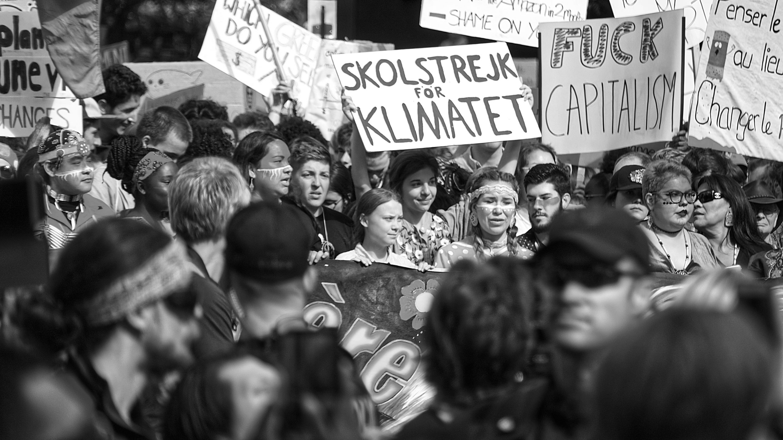 Photo of a demonstration on climate with greta surrounded by other young people.